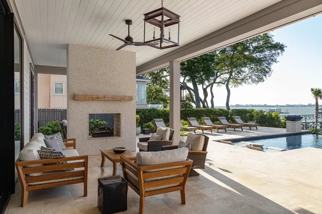 Covered outdoor living space with pool and water view