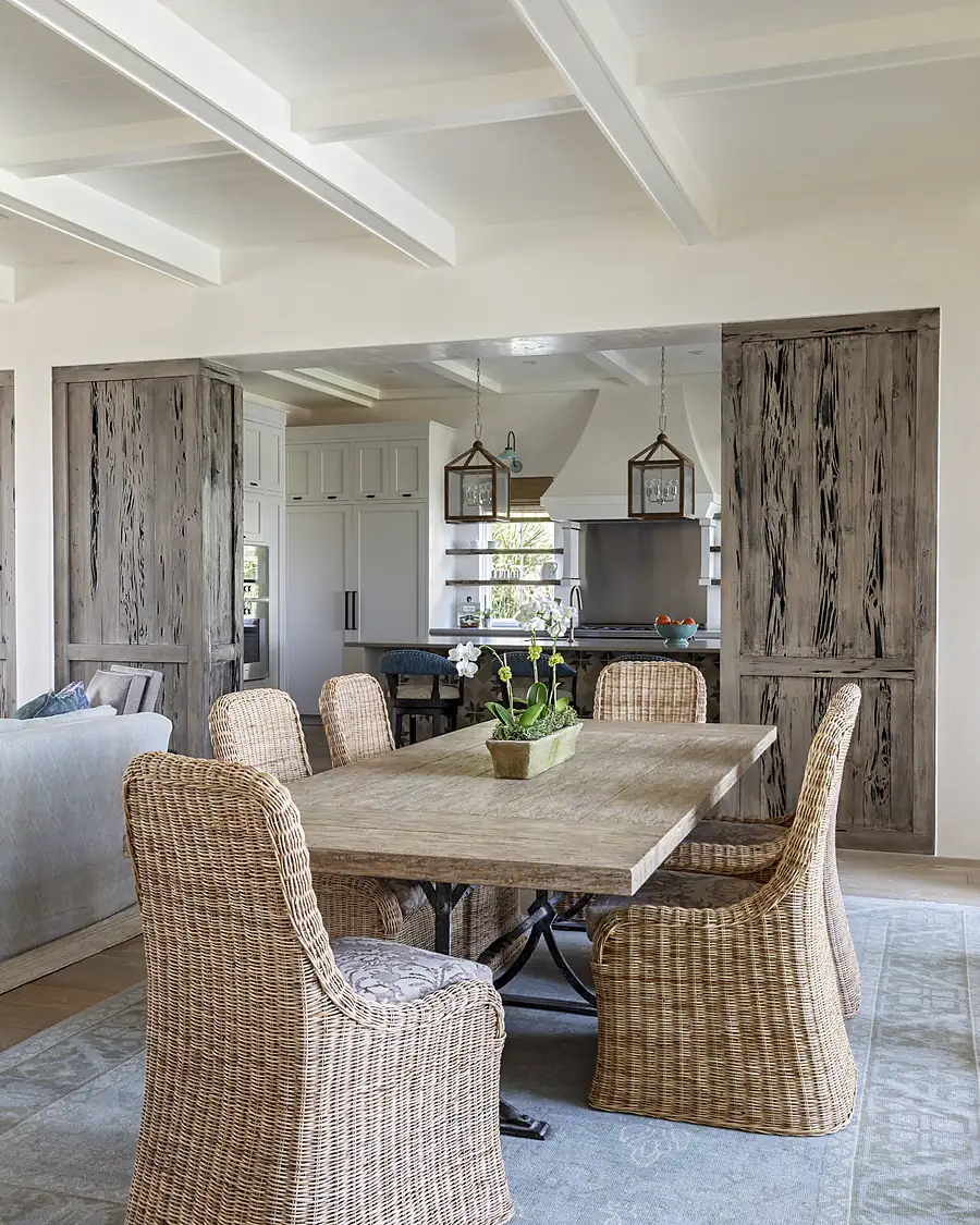 Reclaimed pecky cypress door and stain-grade ceiling beams in a waterfront dining room